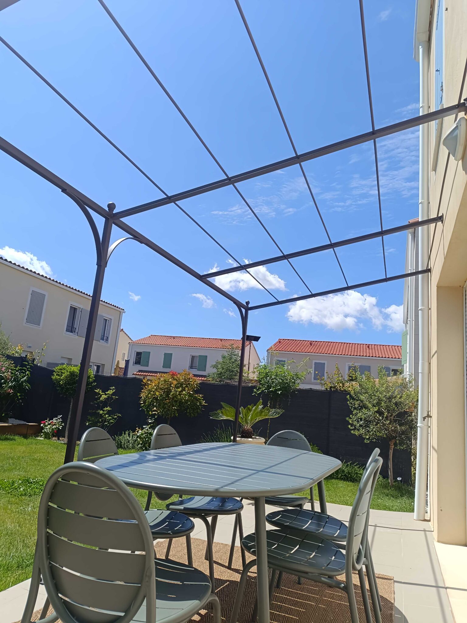 Pergola adossée avec arches métalliques – fixation façade maison