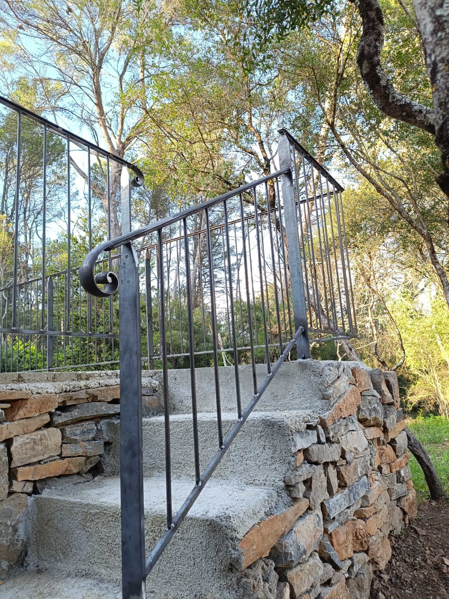 Garde-corps extérieur en fer forgé avec crosse – installation sur escalier en pierre