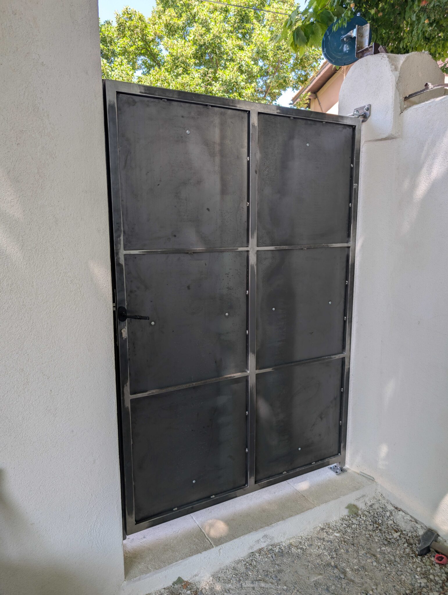 Face arrière d’une porte en acier brut – renforts soudés et fixation murale