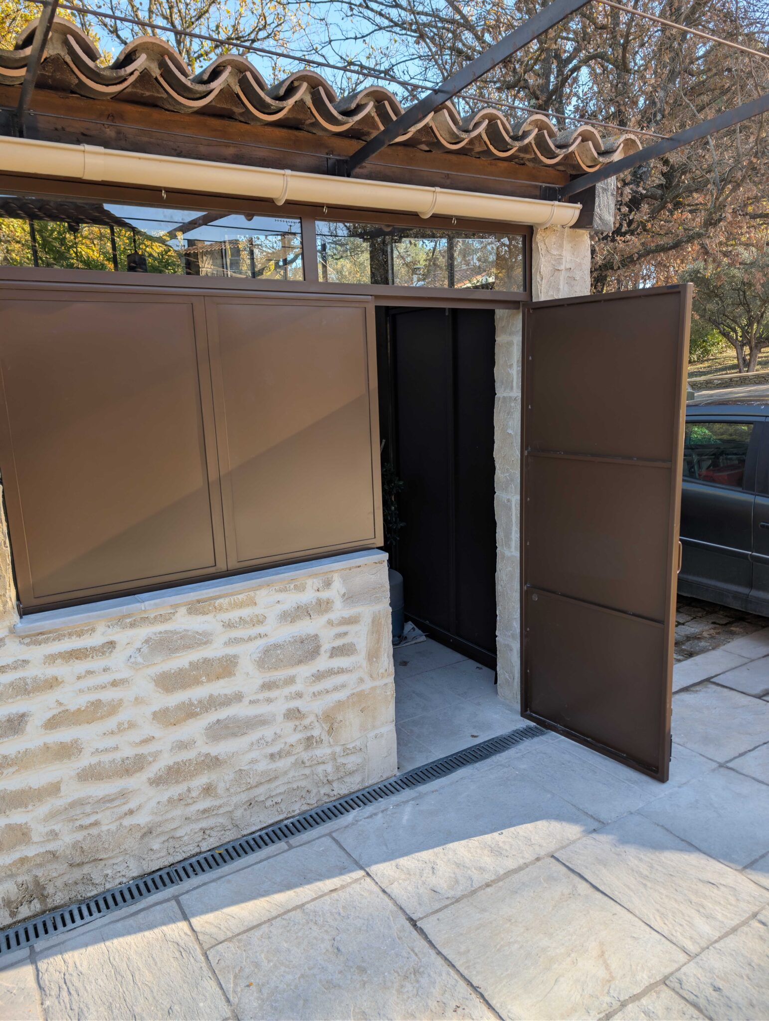 Porte en acier thermolaqué ouverte, accès à la cuisine d’été à Fuveau