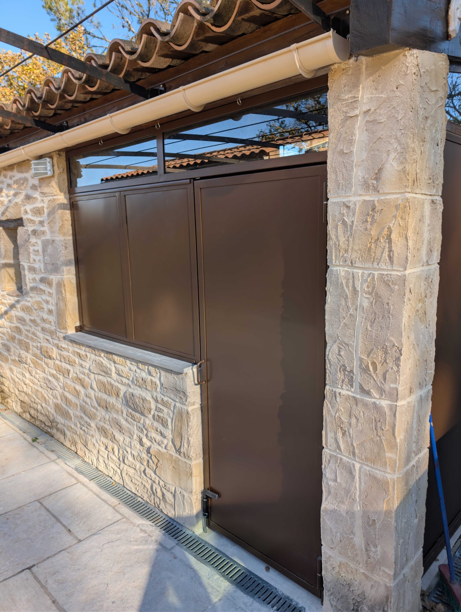 Vue complète de la fermeture de cuisine d’été avec porte, imposte vitrée et panneaux thermolaqués à Fuveau